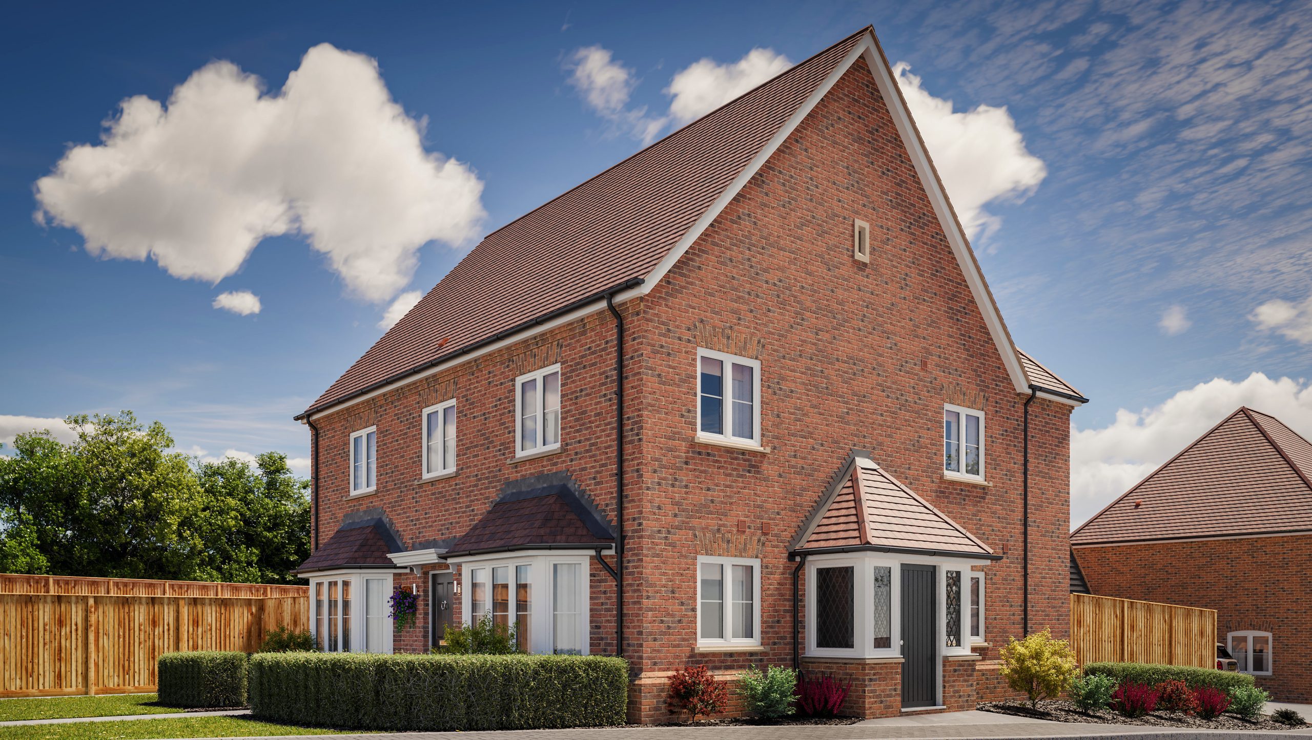A two-story brick house with a triangular roof, well-kept front garden, and clear blue sky.