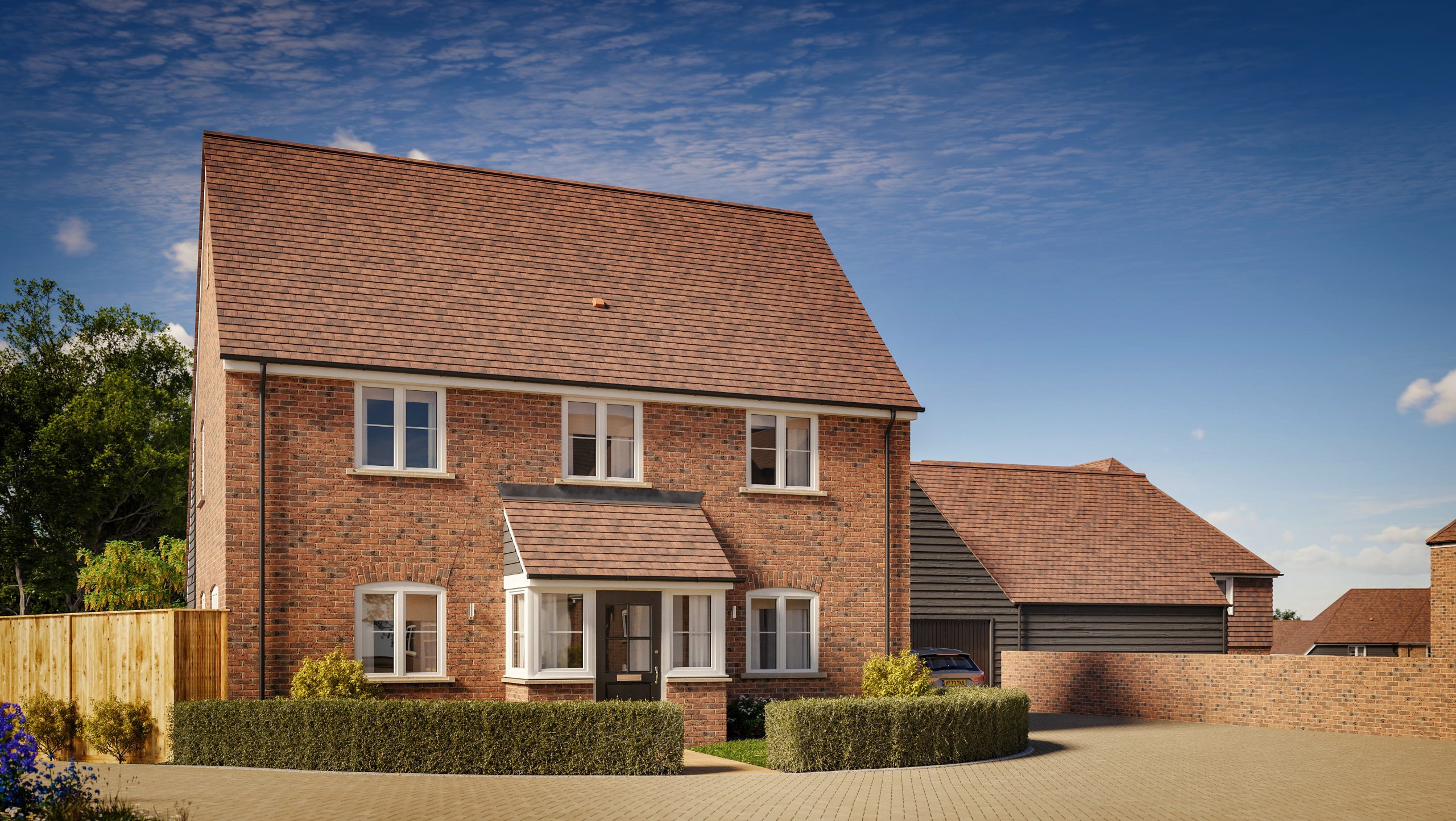 A new two-story brick house with a large drive way, well-kept front garden and a car parked in front of a garage